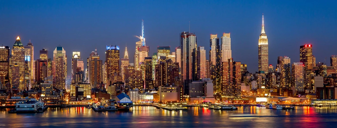 Illuminated skyline reflected across the waterfront at blue hour