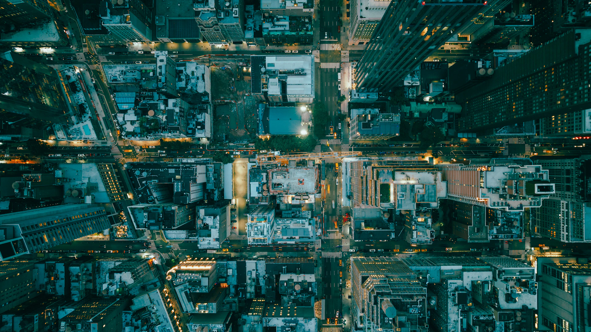 An overhead city view with illuminated streets at night